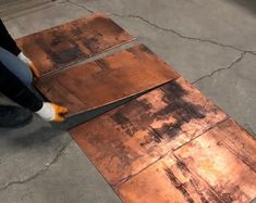 a person is using a saw to cut metal sheets on the ground with a pair of scissors