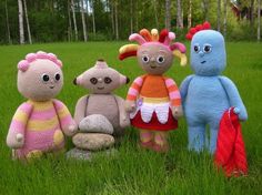 four stuffed animals are sitting in the grass