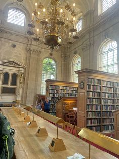 an old library with many bookshelves and chandeliers