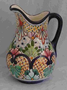 an ornately decorated pitcher is shown on a white background