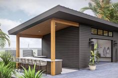 a small house with a covered patio next to palm trees