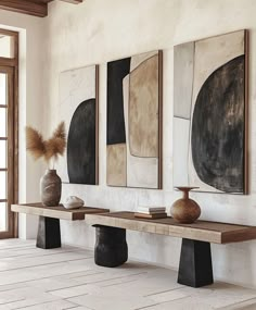 three vases are sitting on a bench in the middle of a room with white walls