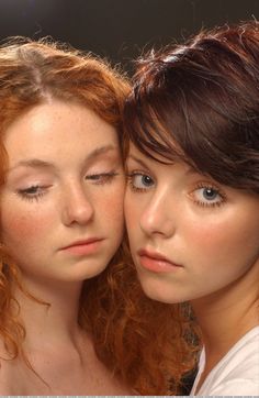 two beautiful young women standing next to each other with freckles on their faces