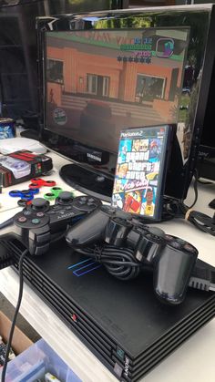 a video game system sitting on top of a desk next to a computer monitor and keyboard