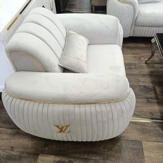 two white couches sitting next to each other on a wooden floor