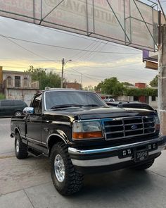 a black pickup truck parked under an overpass