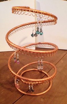 three tiered jewelry holder on top of a wooden table