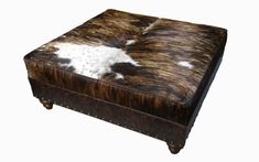 a brown and white cow hide ottoman