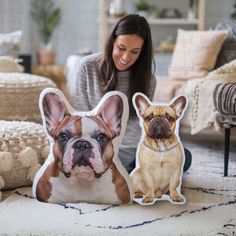 a woman sitting on the floor next to two pillows with dogs cut out of them