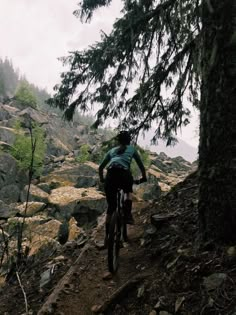 a man riding a bike down a rocky trail