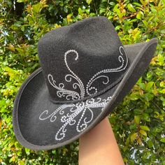 This handcrafted black cowboy hat is beautifully adorned with shimmering rhinestones, creating an elegant swirl design that catches the light from every angle. The wide brim and structured shape make it not only stylish but also functional for sunny outdoor events. Whether you're at a country concert, rodeo, or just out on the town, this hat will add the perfect touch of sparkle and sophistication to any outfit. Rhinestone Decal, Black Cowboy Hat, Chapeau Cowboy, Black Cowboy, Country Concerts, Country Concert, Cow Boy, Swirl Design, Outdoor Events