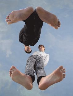 a man is upside down in the air with his legs spread out and feet up