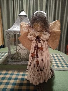 an angel statue sitting on top of a table next to a lantern and other decorations