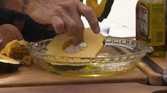 a person is peeling an apple in a bowl on a cutting board next to other ingredients