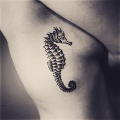 a black and white photo of a sea horse tattoo