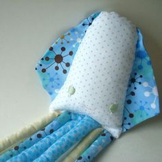 a blue and white stuffed animal laying on top of a table