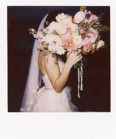 a woman in a wedding dress holding a bridal bouquet