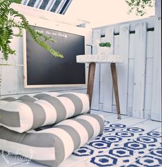 a white and gray striped couch sitting in front of a blackboard