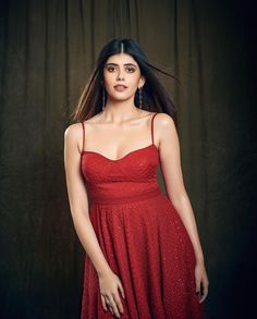 a woman in a red dress posing for a photo