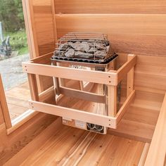 a stove top oven sitting inside of a wooden room next to a window with wood slats on it