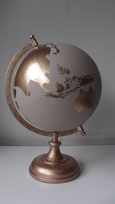 a white and gold globe sitting on top of a table