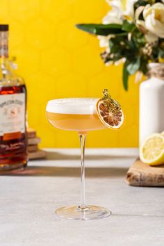 a glass filled with a drink sitting on top of a counter