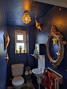 a bathroom with blue walls and gold stars on the ceiling