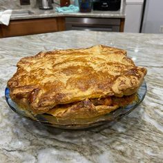 a pie sitting on top of a glass plate on a kitchen counter next to an oven