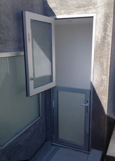 an open door in the side of a building with glass panels on it's sides