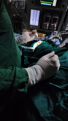 a person with gloves on laying in a hospital bed next to an iv and other medical equipment