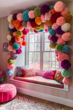 a window seat with colorful pom - poms hanging from it's side