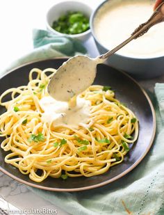 a fork is being used to dip sauce over spaghetti