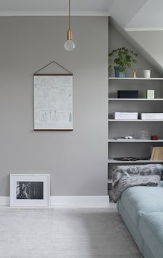 a bedroom with a bed, bookshelf and pictures on the wall above it