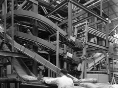 an assembly line in a factory with workers working on the machinery and bags being unloaded