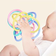 a baby is playing with some rubber rings