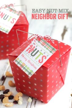 two red gift boxes with the words easy nut mix neighbor gift on them and some nuts scattered around