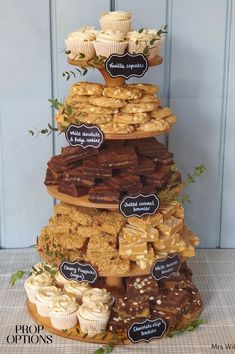 a tall tower filled with lots of different types of cakes and cupcakes on top of each other