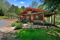 a small cabin in the middle of a wooded area with lots of trees and grass