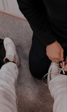 a person tying up their shoes on the ground