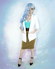 a woman with blue hair is standing in front of a wall wearing a white blazer and brown skirt