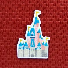 a red background with a blue and pink castle sticker on the bottom right corner