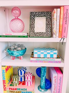 a book shelf filled with lots of books and other assorted items on top of it