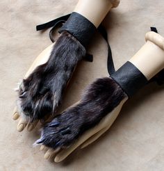 two hands with black and grey fur on them, tied to a mannequin's arm