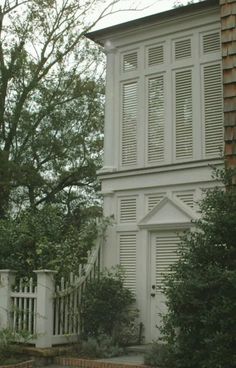 an old house with white shutters on the front