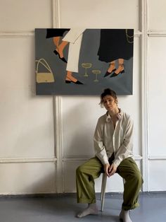 a woman sitting on a chair in front of a painting