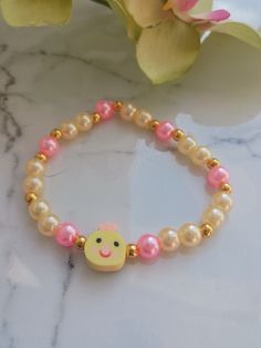 Perfect for Easter or just because! This pale yellow and pink pearl bracelet features the sweetest little chick face. It's sure to bring a smile to your face! These are handmade at the time of order and are made using high-quality stretchy cord and beads. However, they are delicate, and I recommend you do not wear while sleeping, swimming, bathing, or working out.   One size fits most. Standard bracelet size is 7 inches. If you need a custom size, please message me. Please measure your wrist bef Pink Novelty Stretch Bracelet For Birthday, Novelty Pink Stretch Bracelet For Birthday, Cute Pink Pearl Jewelry, Cute Pearl Beaded Bracelets As Gift, Pink Novelty Stretch Bracelet As A Gift, Pink Novelty Stretch Bracelet As Gift, Pink Novelty Stretch Bracelet For Gift, Cute Handmade Pearl Bracelet Gift, Pink Adjustable Pearl Stretch Bracelet