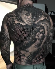 the back of a man's body with tattoos on it, and two people