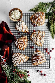 christmas cookies with icing and cranberries on a cooling rack