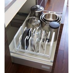 an organized kitchen drawer with pots and pans