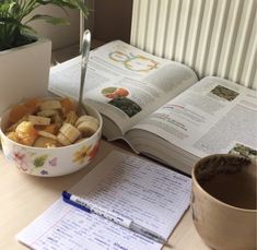 a bowl of food next to an open book